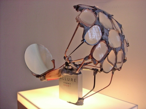 Perfume SOS (Allure Beacon) 2004. Perfume bottle, eyewear, mirror, comb, cotton wick & melted plastic
